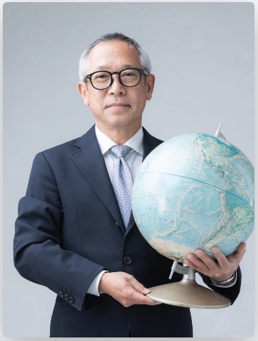 代表者ポートレート - 地球儀を持ち、300回以上の渡航・350都市以上の経験を持つスペシャリスト